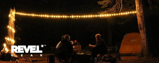 campers sitting under decorative camping lights, image